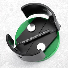 Green and black circular object with a central component on a light gray background