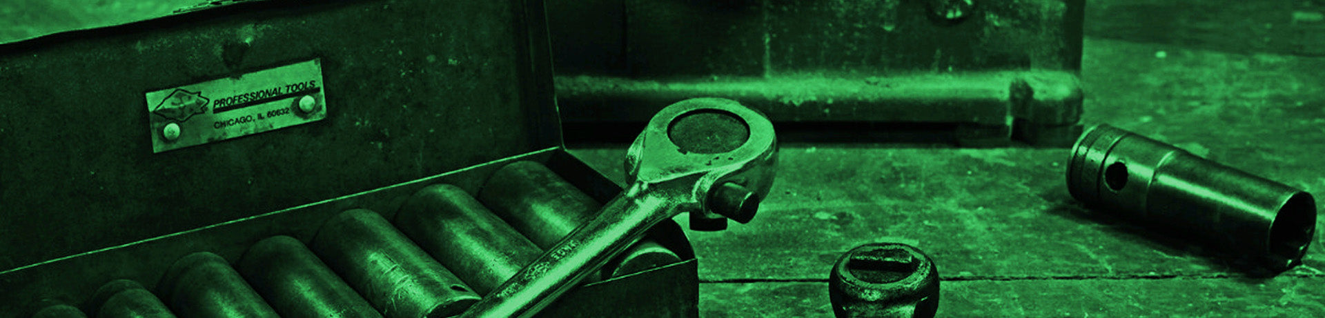 Wrench and other tools on a wooden surface with a green filter.